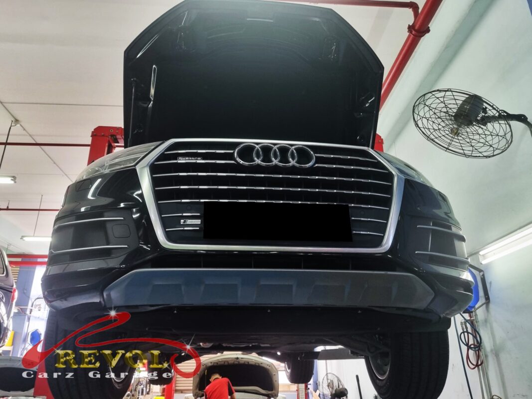 Q7 raised on the lift with rear wheels off for shock access.
