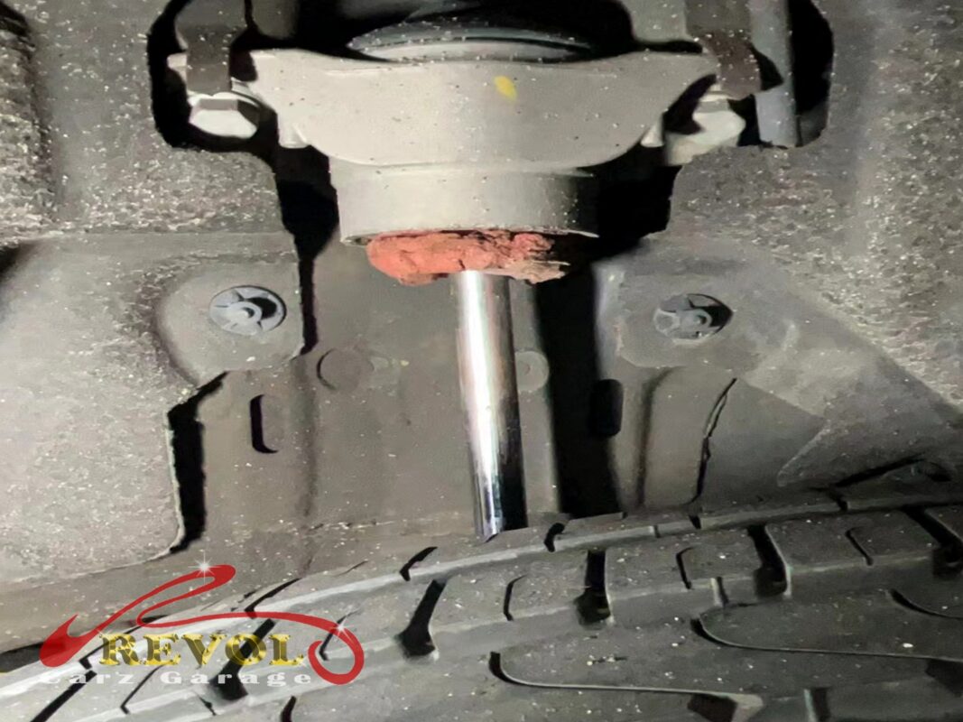Old rear absorber removed, oil weep down the body visible.