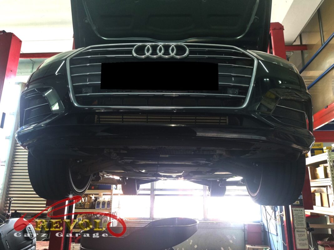 A5 front suspension with the wheel off, knuckle dropped for arm access.