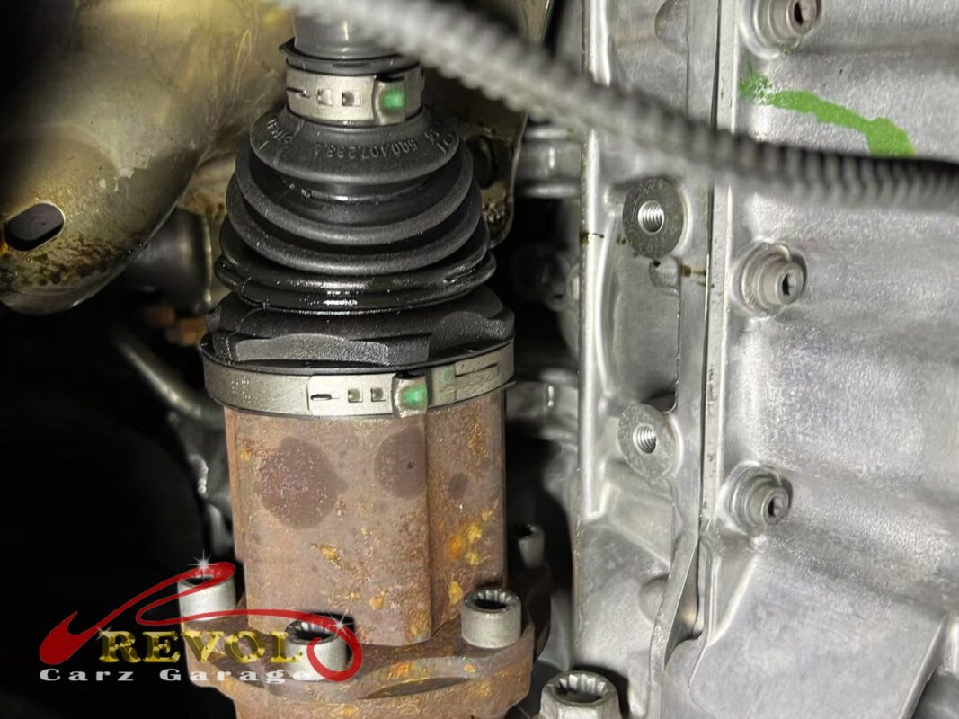 Torn driveshaft boot with grease flung across the underbody.