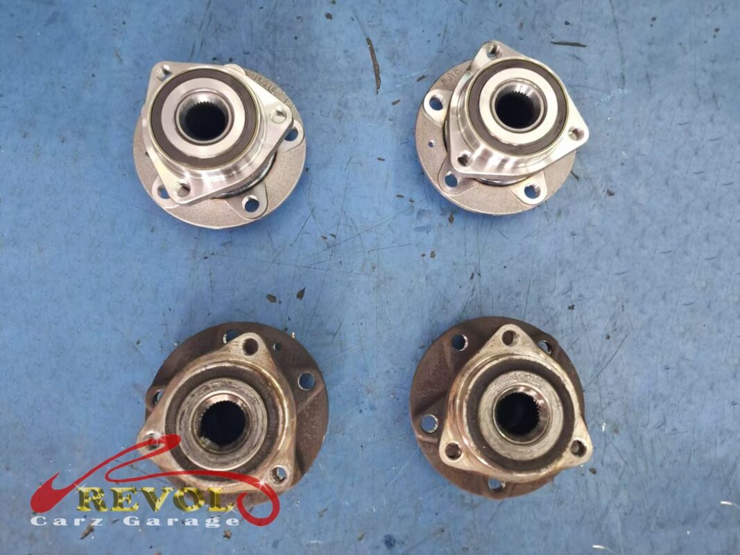 The two worn wheel hub bearings out (bottom, rusted and rough) next to the two new replacements (top, ready to fit).