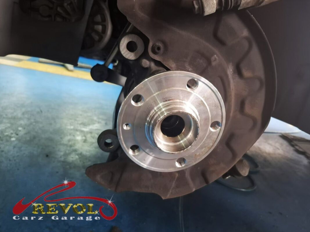 A new wheel hub bearing fitted to the steering knuckle on the car, brake disc back in place, ready to torque up.