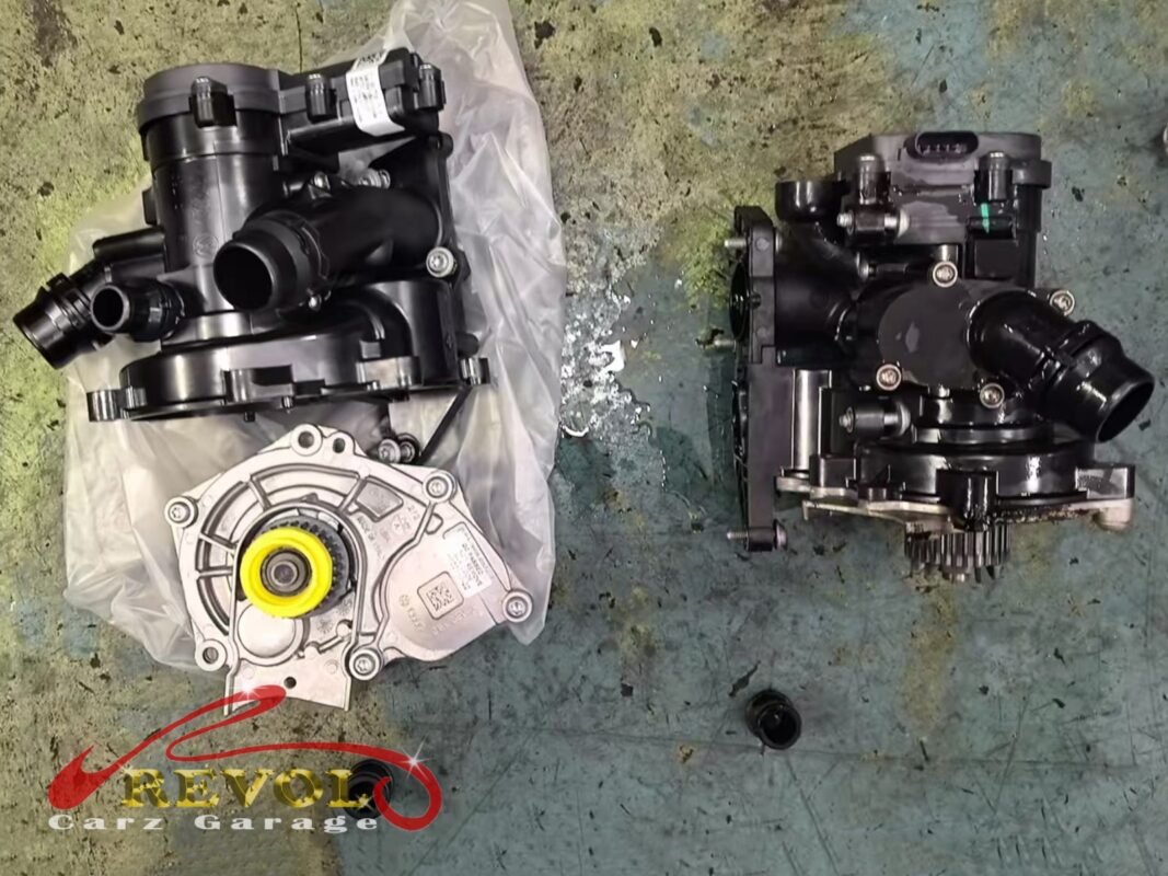 The old water pump module out (right, grimy) next to the new VAG-spec replacement (left, still bagged). Pump and thermostat housing come as one unit on this engine.