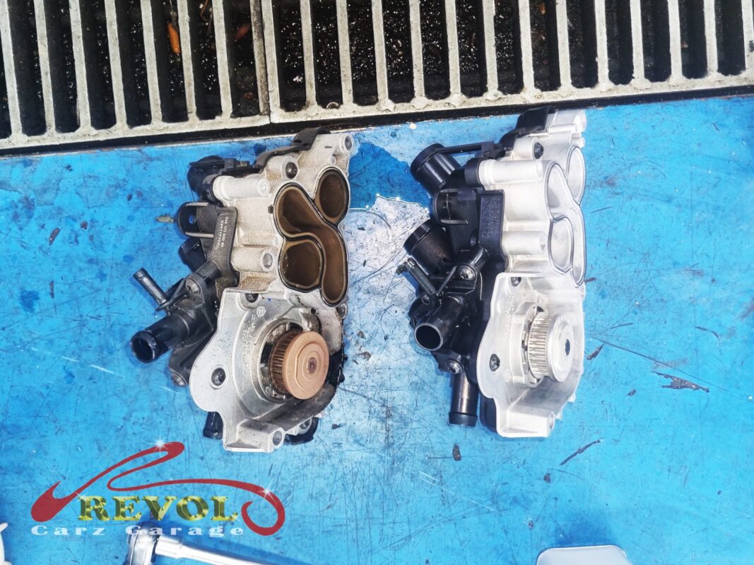 The old water pump module (left, grimy) next to the new VAG-spec replacement (right). Pump and thermostat housing come as one unit on this engine.