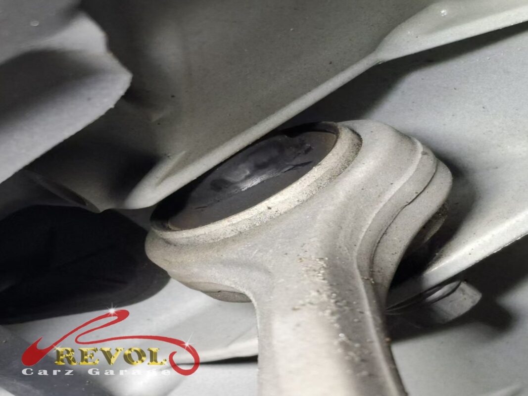 A close look at one of the worn control-arm bushings, the rubber starting to crack and split.