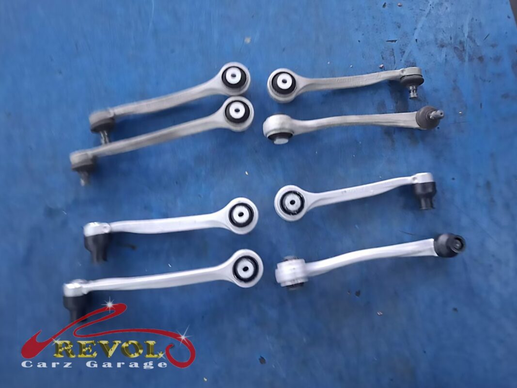 The full set of new Audi-spec front control arms laid out before fitting. On this multilink front end the arms wear together, so the whole set went in rather than just the worst pair.