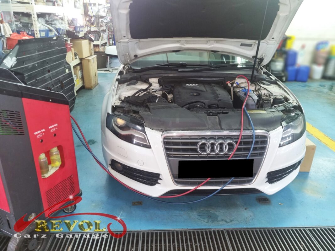 The A4 with the AC service machine connected, recovering the old refrigerant before the compressor comes off.