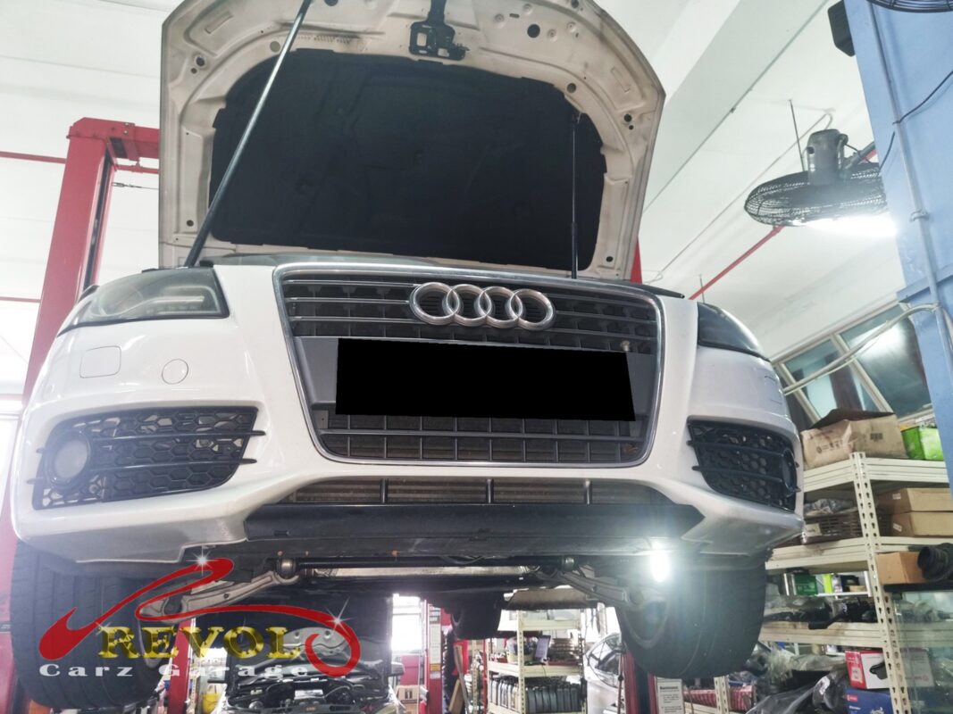 The A4 up on the two-post lift, front end raised for access to the compressor and its drive section.