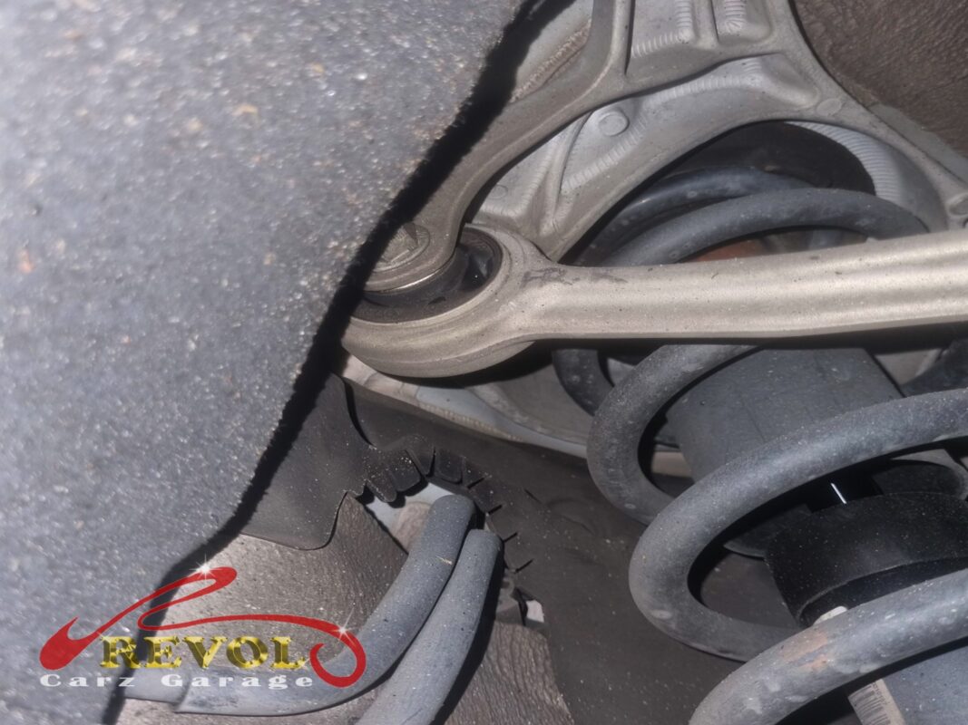 A look at the front suspension from underneath, control arm and coil spring in view.