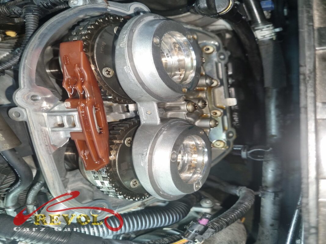 The timing cover off, with the camshaft sprockets, timing chain and chain tensioner exposed.
