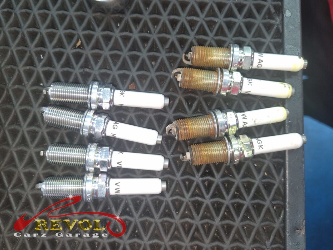 The four old spark plugs (right, threads discoloured) next to the four new VAG-spec replacements (left).