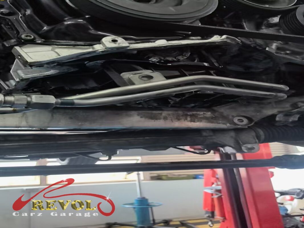 The underside of the A4 on the lift, oil staining visible down the subframe crossmember below the sump.