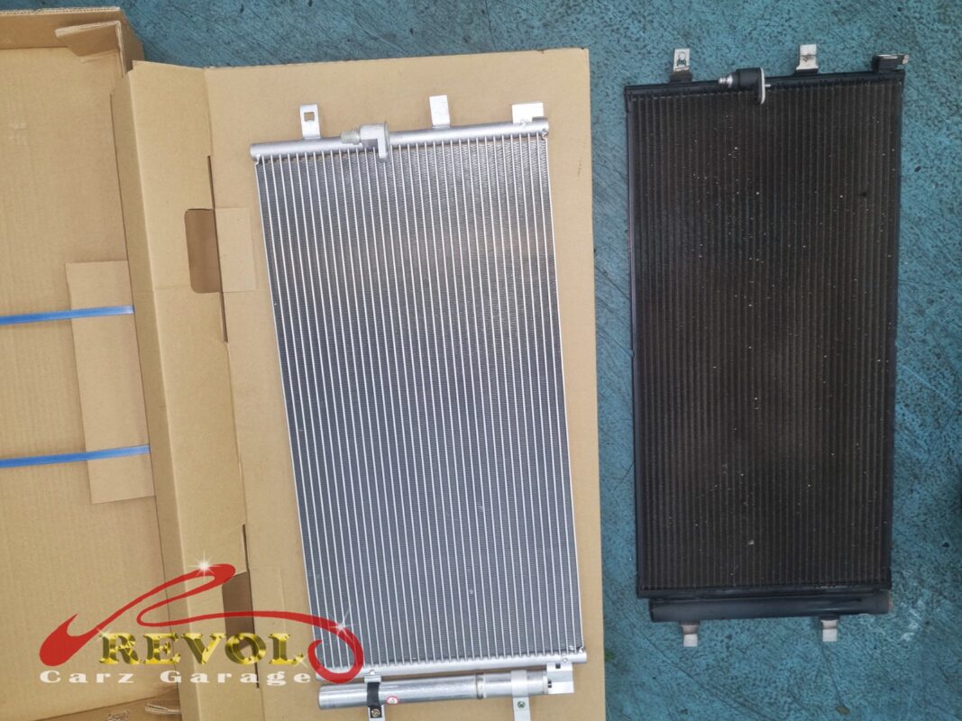 The new Audi-spec AC condenser (left, still boxed) next to the old one (right, oxidised and grimy after years up front in the airflow).