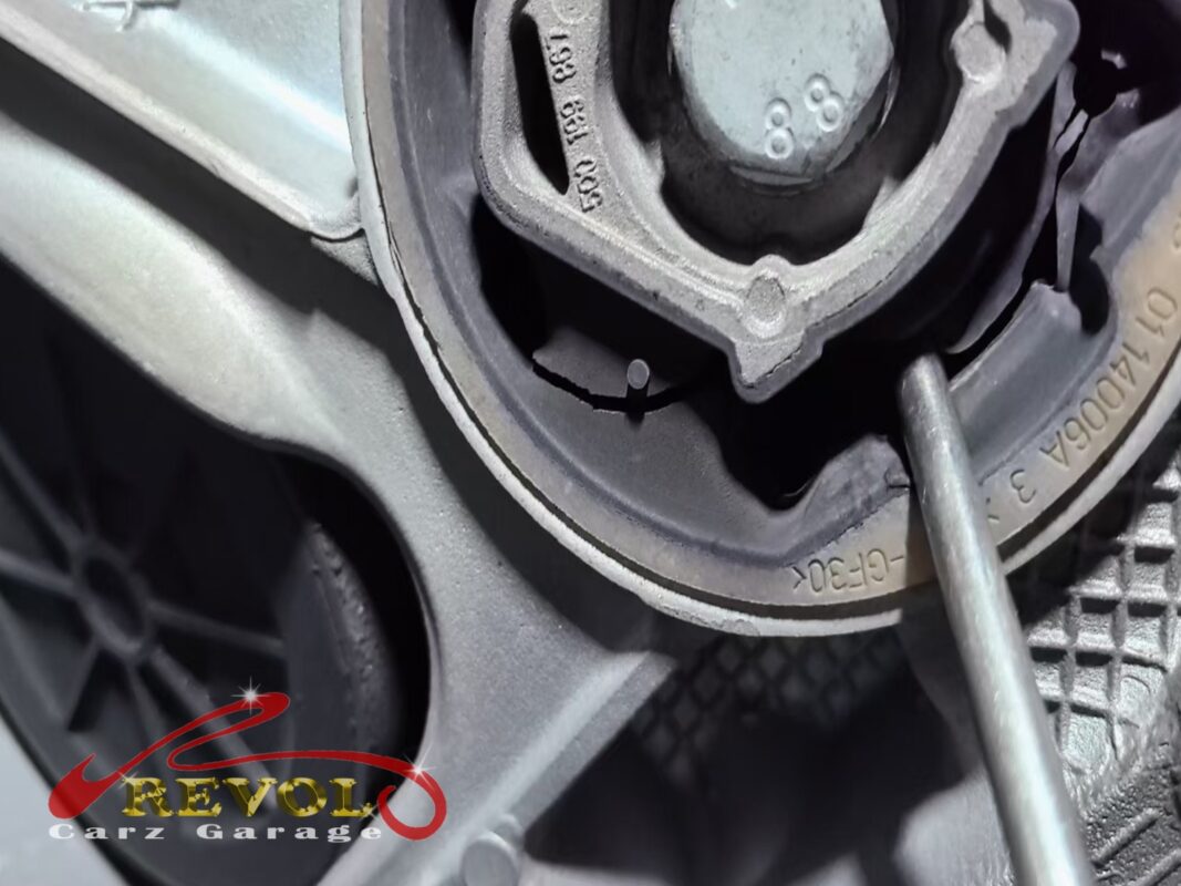 A pry-test on one of the front subframe bushings, levering against it to check how far the rubber deflects.