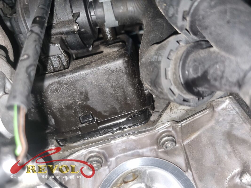 The oil separator unit in place on the side of the engine, the housing grimy with oil mist drawn through a failed diaphragm.