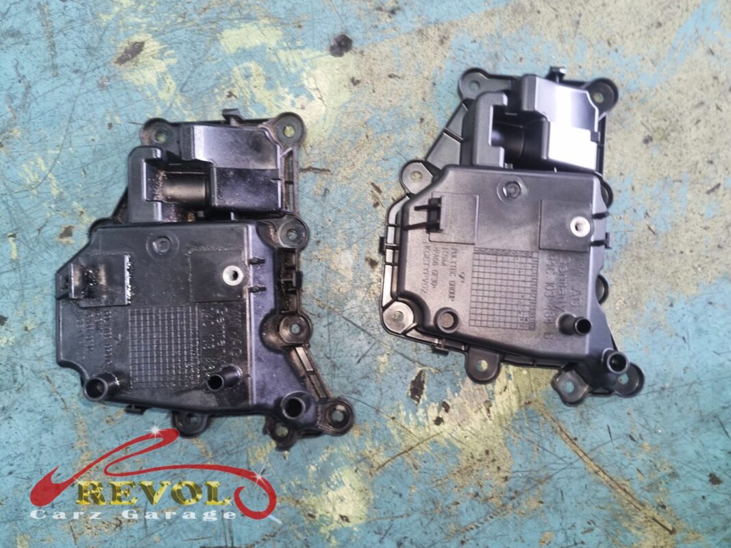 The old oil separator (left, oily and dark) next to the new VAG-spec replacement (right).