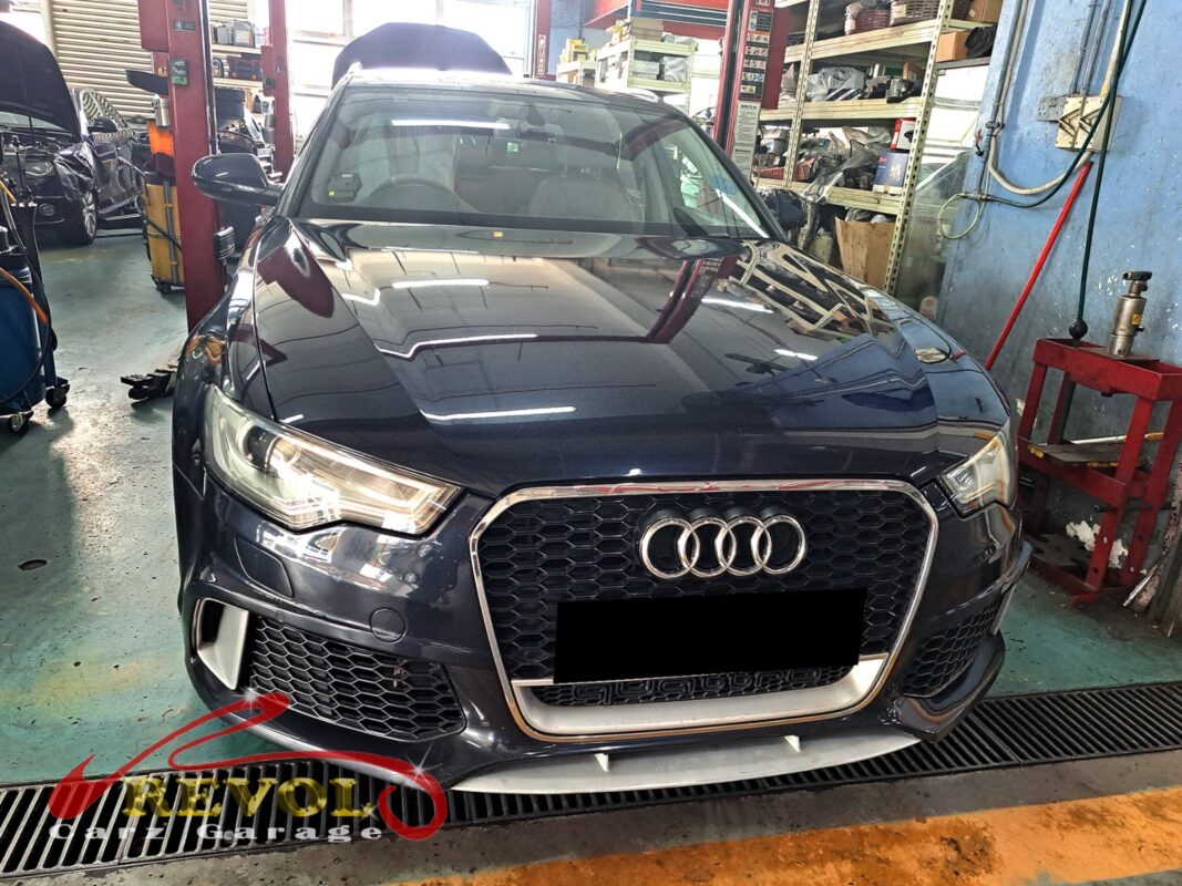 Audi A6 on the workshop lift with the front bumper open for radiator replacement.
