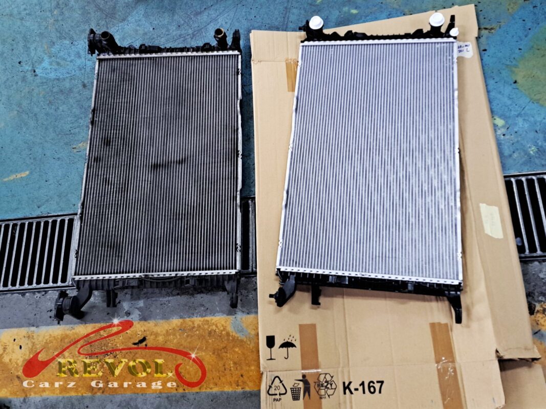 The old radiator (left, oxidised) next to the new Audi-spec replacement (right, on its packaging).