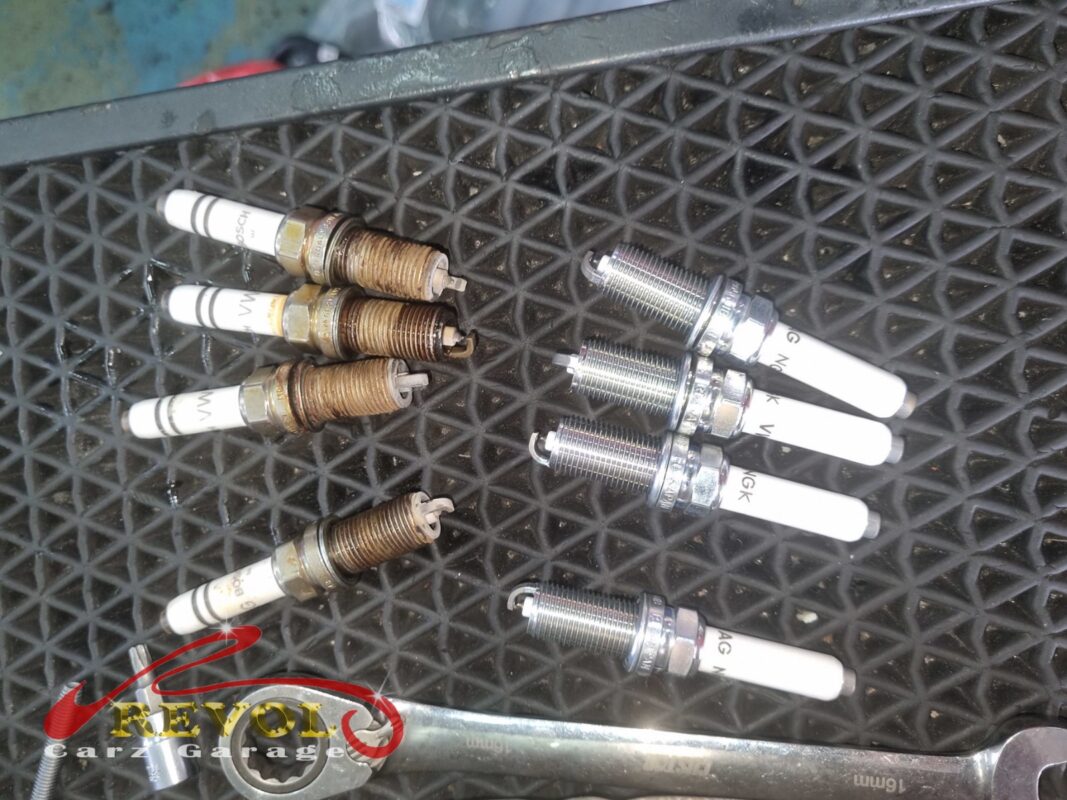 The four old spark plugs (left, rusted threads) next to the four new VAG-spec replacements (right).