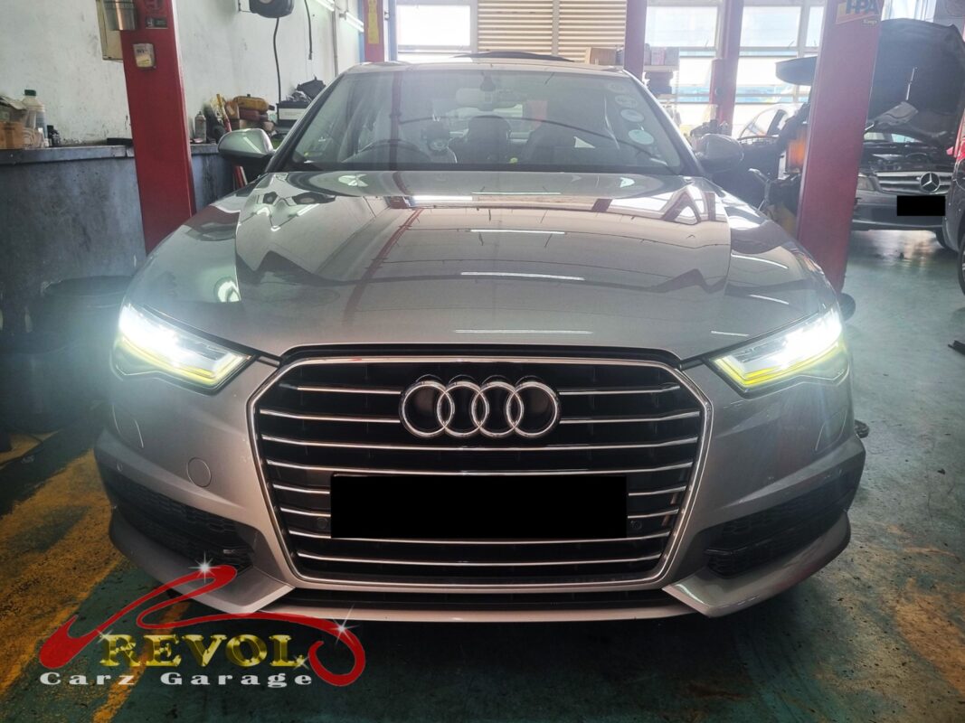 Audi A6 with the engine bay open for thermostat replacement.