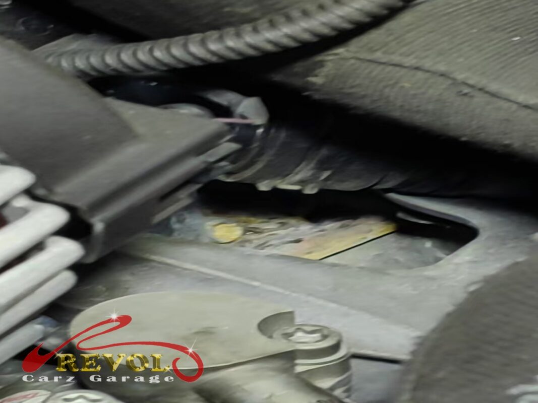 Coolant traces, dried yellowish-green, around the thermostat housing in the engine bay.