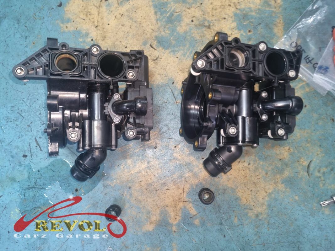 The old thermostat housing assembly (left) next to the new Audi-spec replacement (right), with fresh O-ring seals.