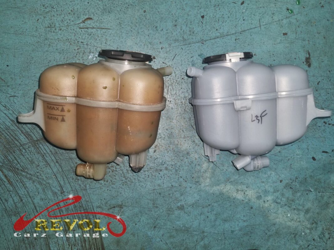 The old expansion tank (left, stained and discoloured) next to the new VAG-spec replacement (right).