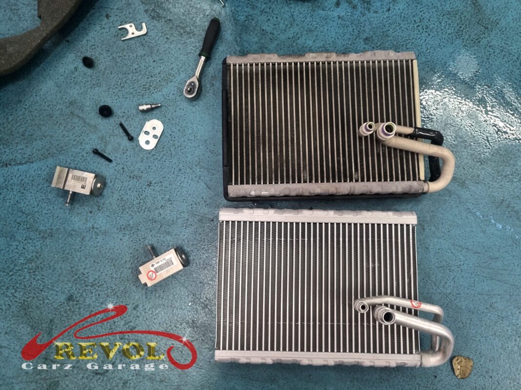 The old evaporator core (top) next to the new Audi-spec replacement (bottom), with a fresh expansion valve and seals alongside.