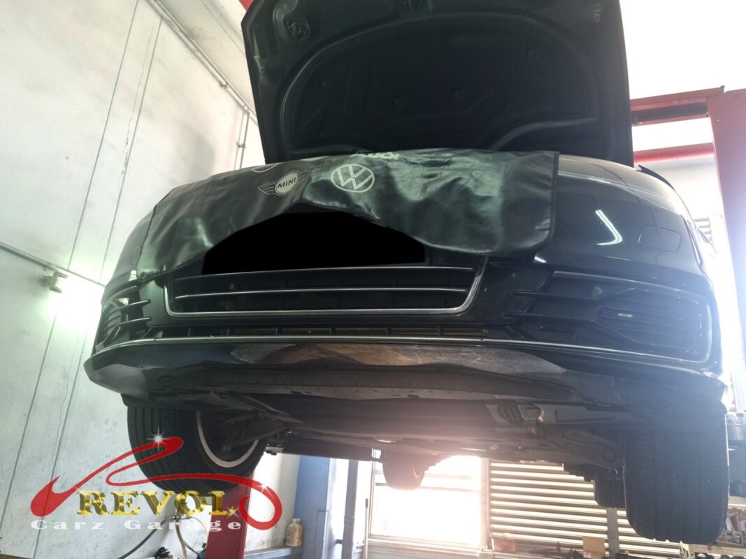 The Audi A6 up on the two-post lift, fender cover on, in for its maintenance service.