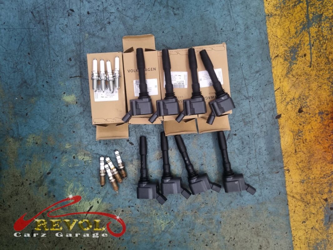 The old plugs and coils (lower left) alongside the full set of new VAG-spec replacements, the coils still in their boxes.
