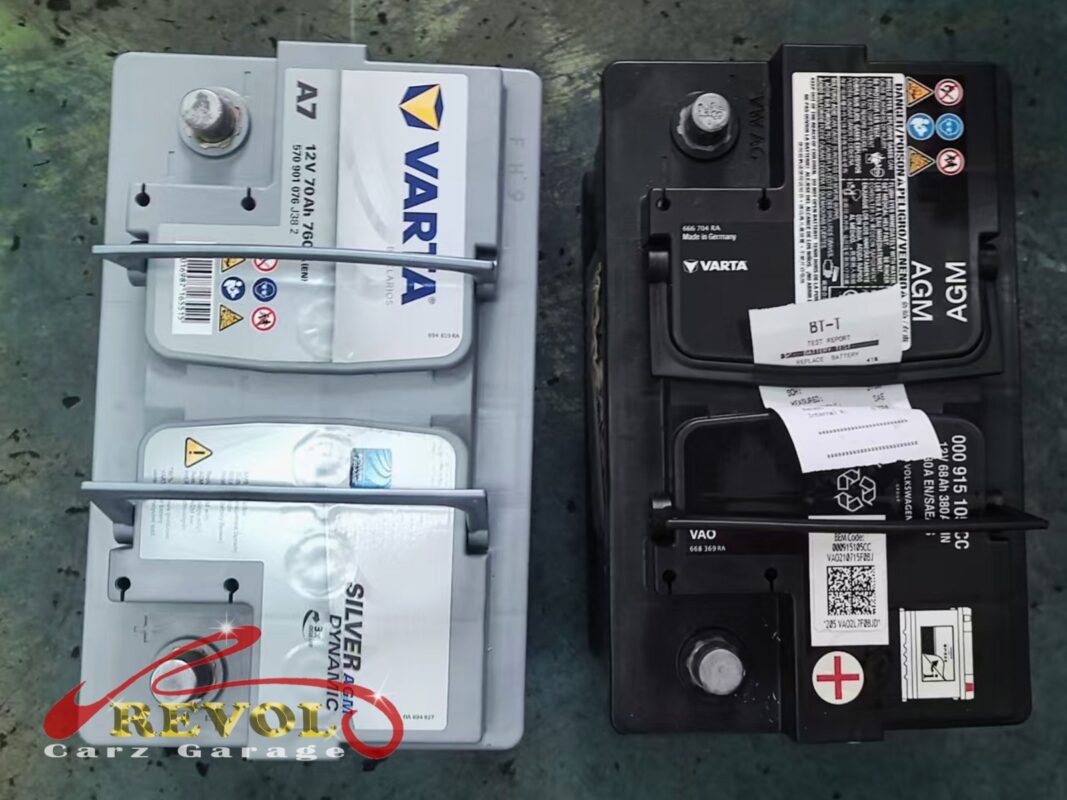 The new VARTA AGM battery (left, still wrapped) next to the old one (right, the test printout taped on it).
