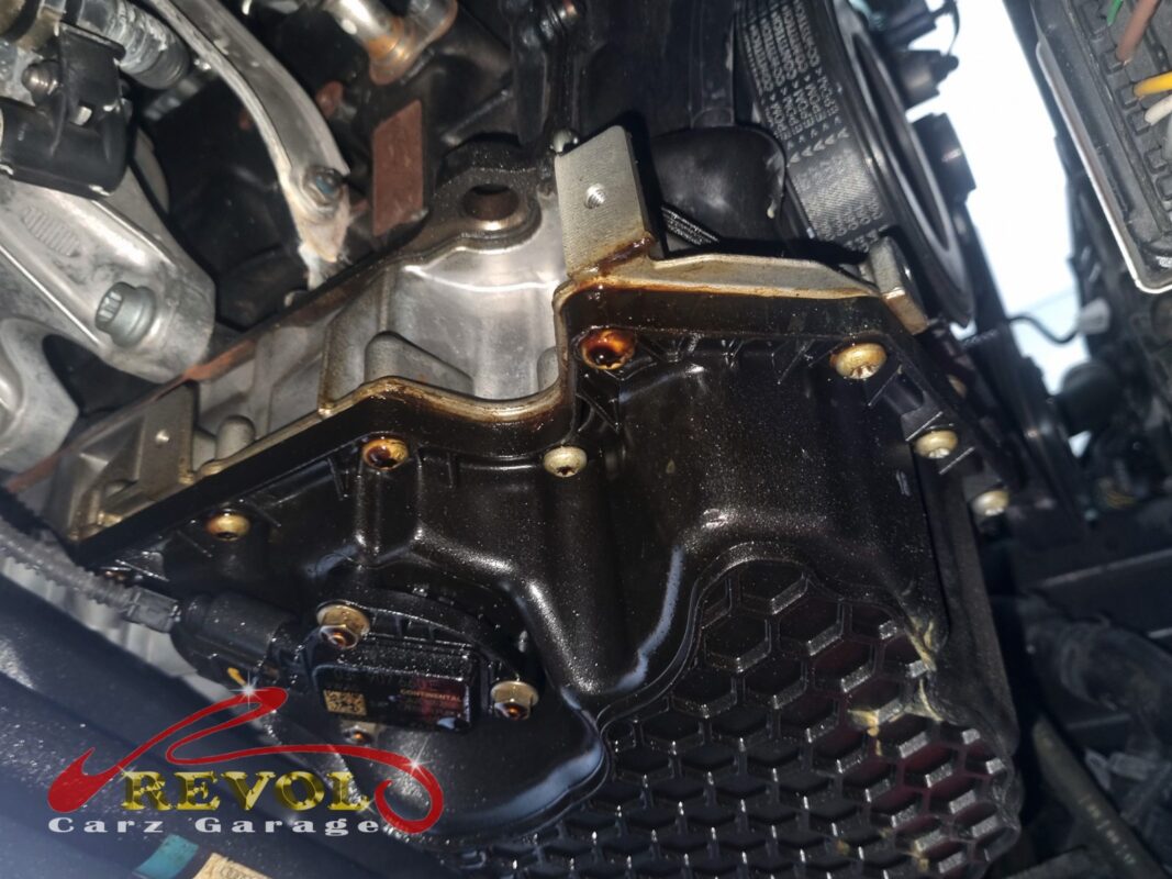The sump pan area before the strip-down, the joint and the oil level sensor slick with weeping oil.