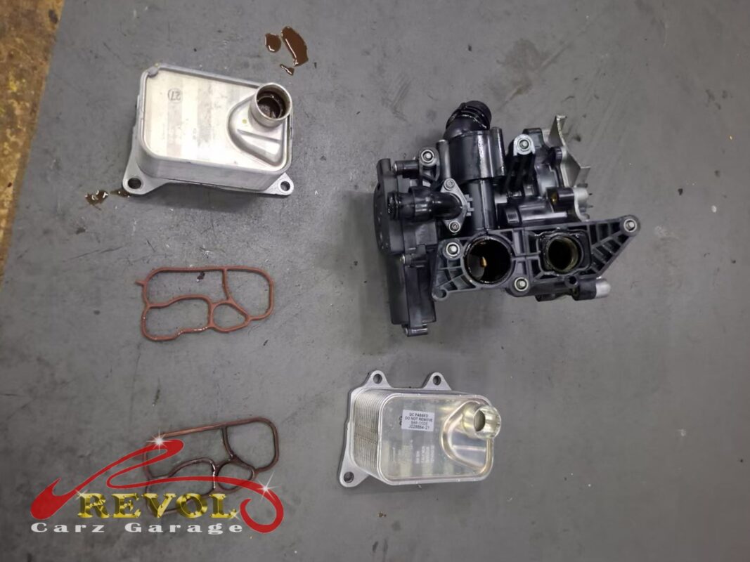 The old oil cooler and its seal (top left) next to the new ones (bottom right), with the cooler housing module alongside.