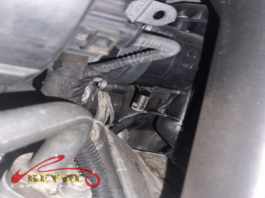 The water pump area in the engine bay, damp coolant residue at the housing where the shaft seal had been weeping.