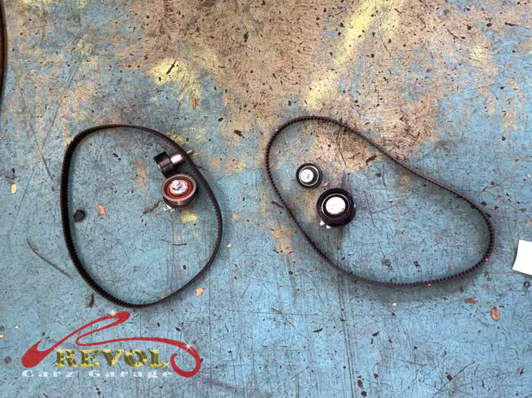 The old timing belt and pulleys (left) next to the new VAG-spec belt kit (right): belt, tensioner and idlers, with the water pump done at the same time.