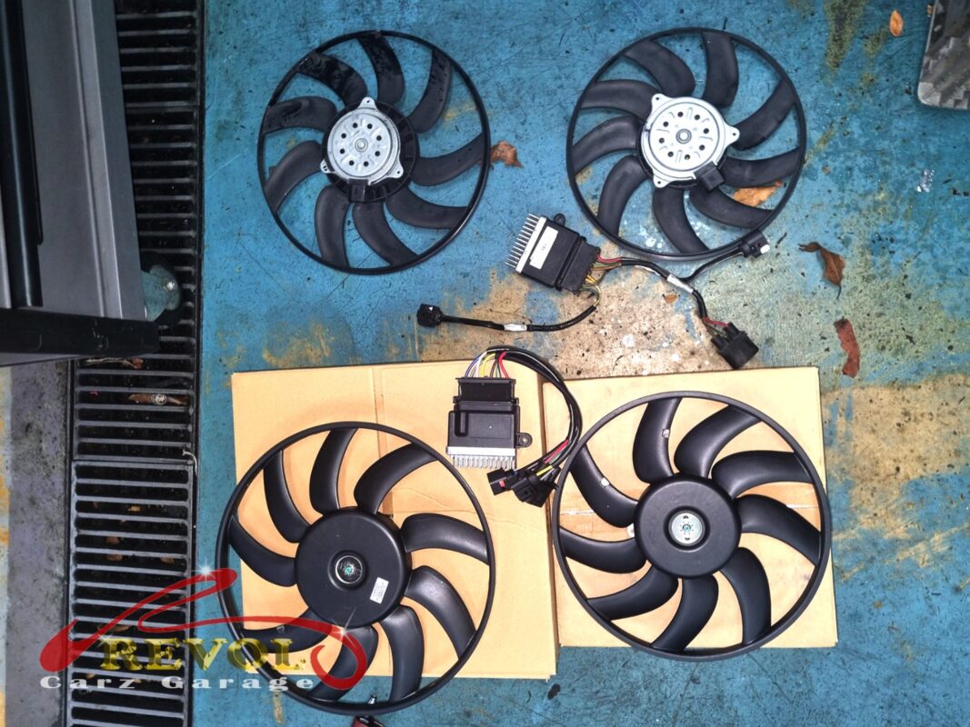 The old twin radiator fans (top, grimy) next to the new Audi-spec replacements (bottom), with the fan control modules alongside.