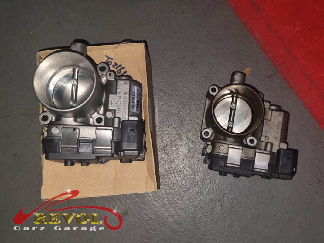 The new VAG-spec throttle body (left, still boxed) next to the old one (right, grimy after a self-clean that bought a day).
