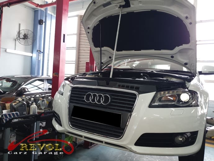 The Audi A3 with the bonnet sitting misaligned, the pneumatic struts given up.