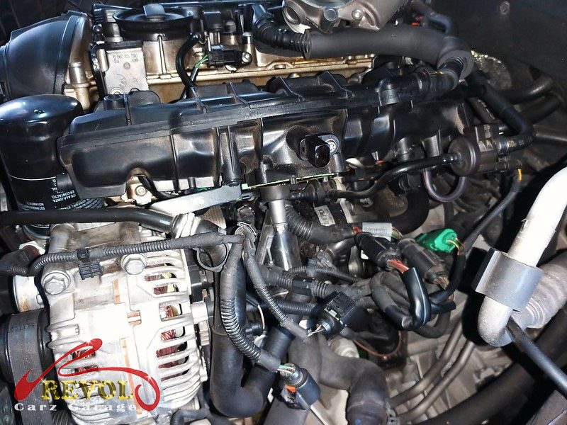 The old cracked plastic coolant flange removed from the engine.