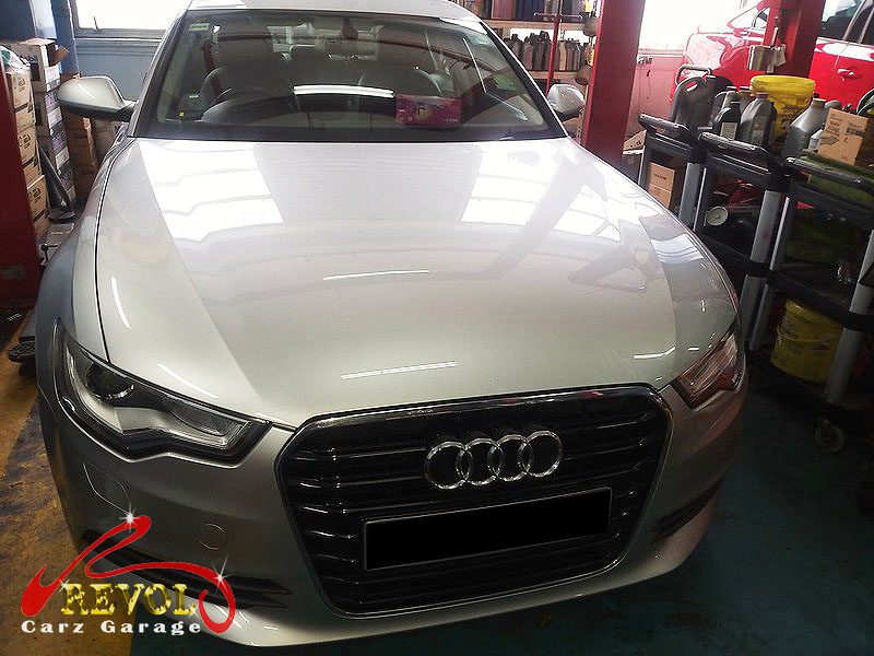 Audi A6 parked at the workshop for a service, front brakes and a coolant cap.