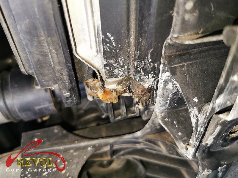 The old cracked radiator removed from the front of the car.
