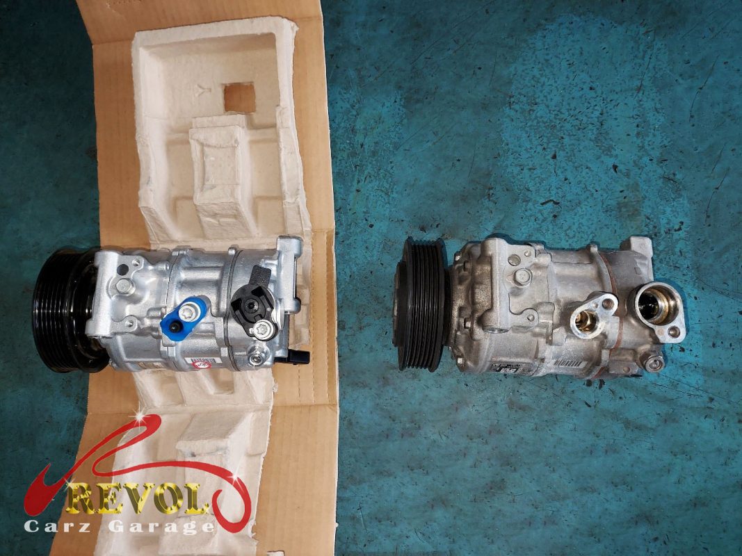 The old failed compressor removed alongside the new compressor and receiver-drier.