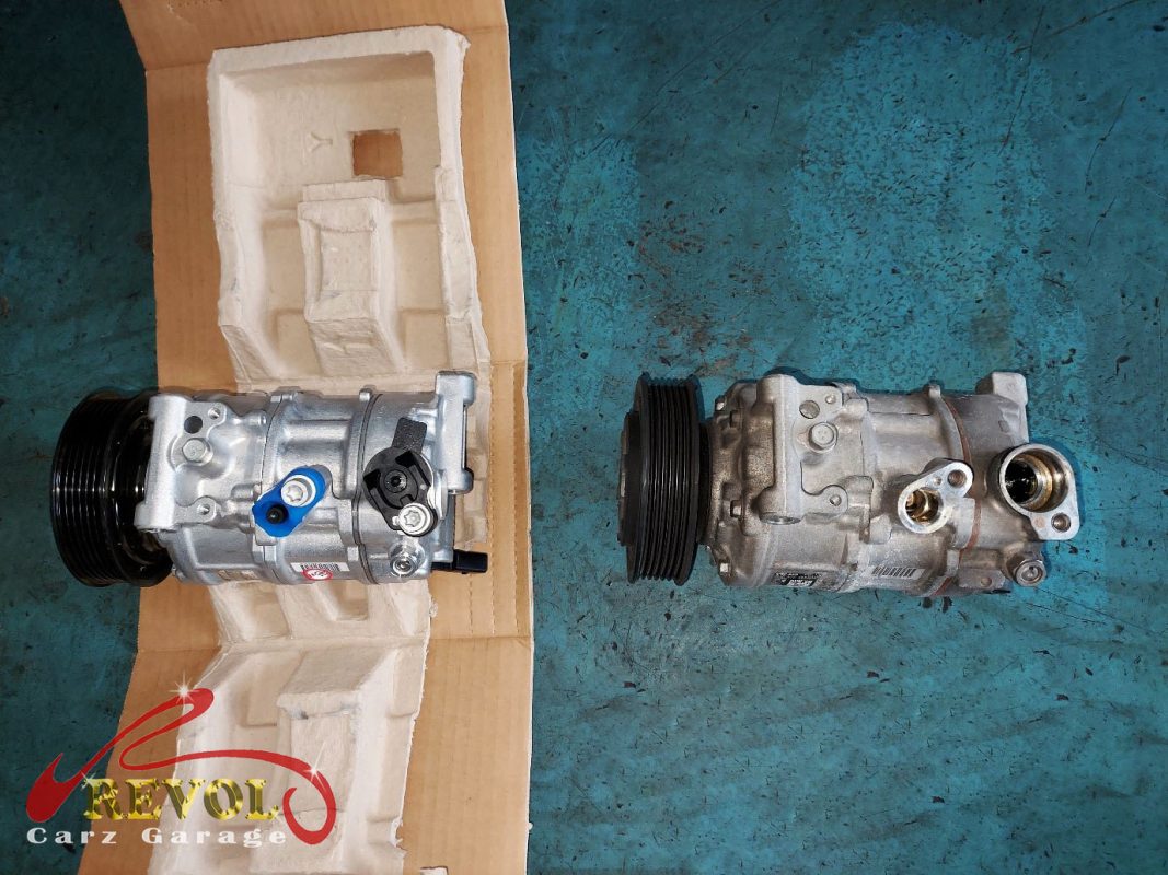 The old failed compressor removed alongside the new compressor and receiver-drier.
