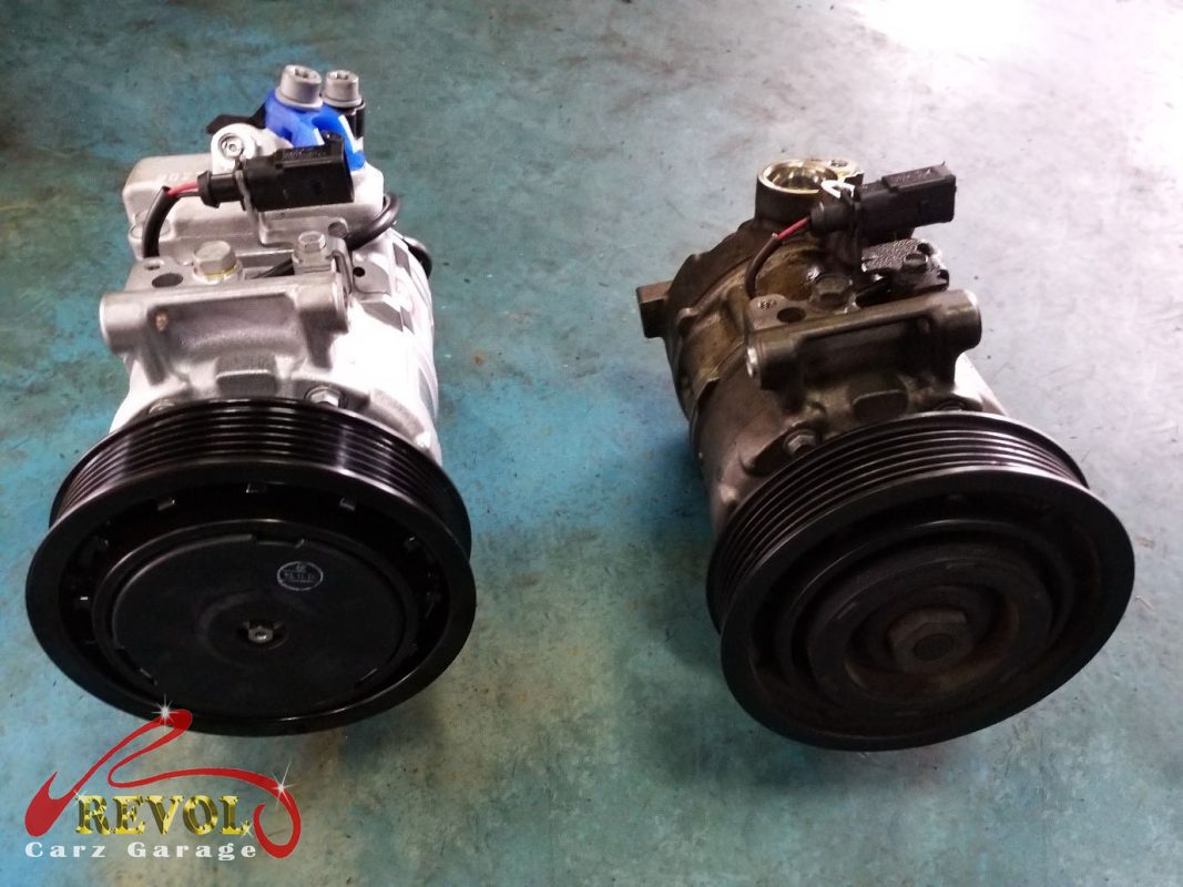The old failed compressor removed alongside the new compressor and receiver-drier.