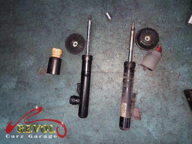 Both old front struts removed and lined up against the new pair.