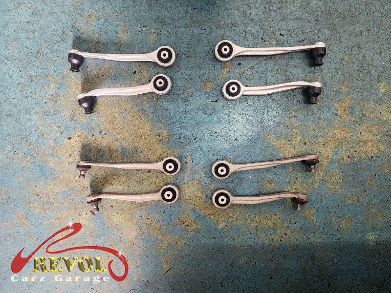 The worn front upper control arm with play in its ball joint removed.