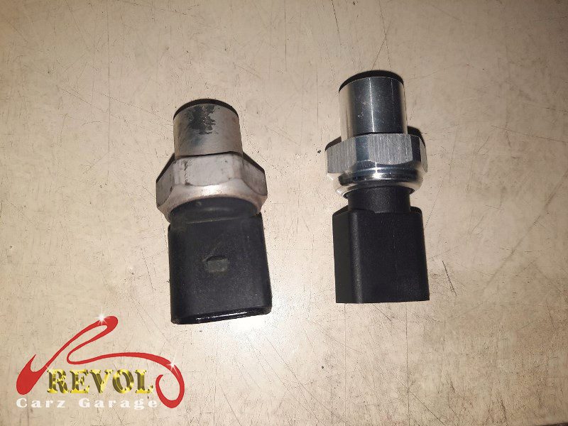 The old failed compressor removed alongside the new compressor and receiver-drier.