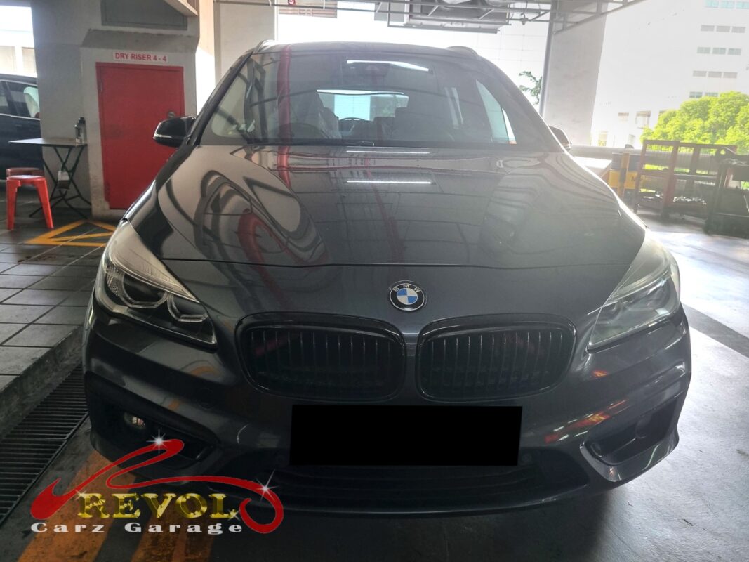 BMW 216i with the engine bay open for oil cooler diagnosis.