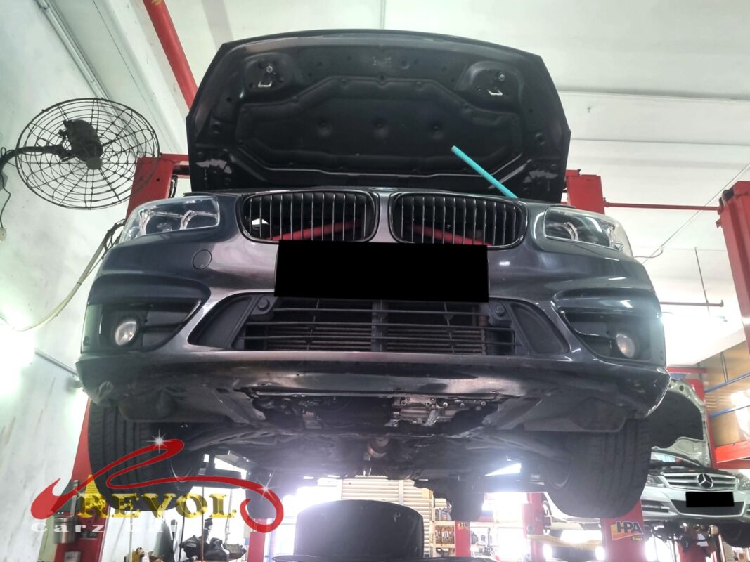 The BMW 216i up on the two-post lift, towed in with the oil pressure light on.