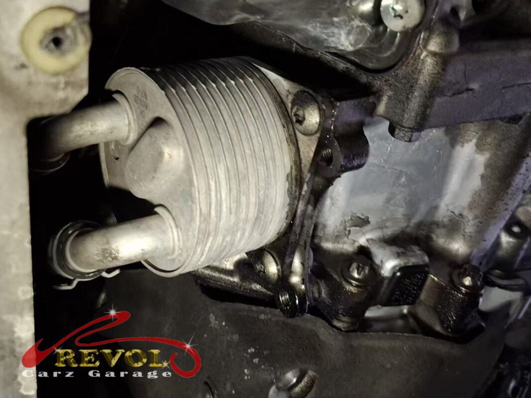 The oil cooler on the side of the engine, oily residue around the housing where the gasket had been leaking.